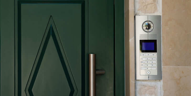 Doorbell camera on the right hand side of a dark green front door. 